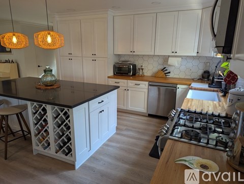 A kitchen with white cabinets and a black countertop.