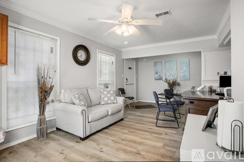 A living room with a white couch and a ceiling fan.