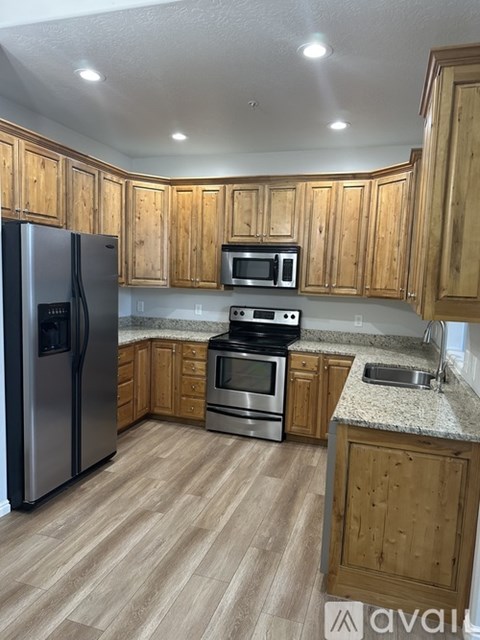 A kitchen with wooden cabinets and a granite countertop.
