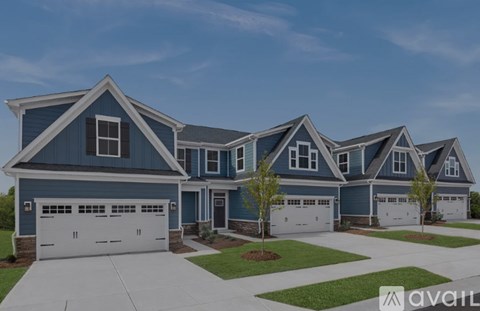 A large, modern house with a blue exterior and multiple garages.
