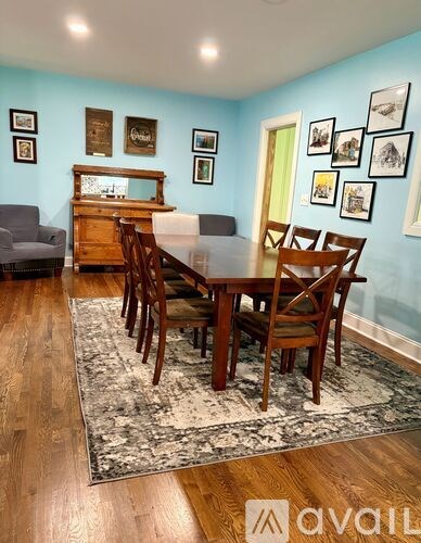 A dining room with a wooden table and chairs.