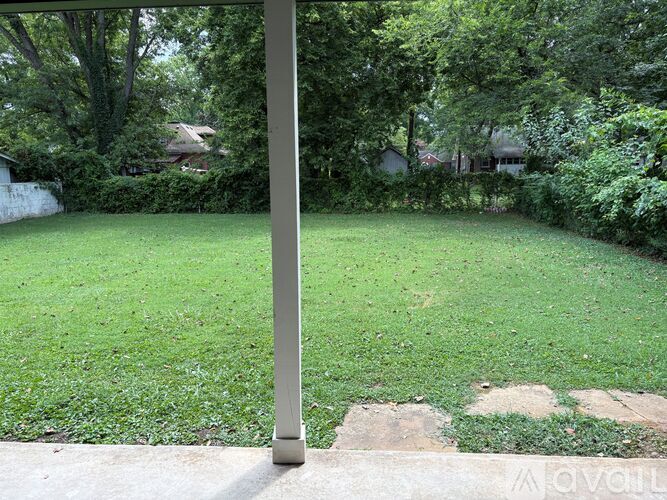 A grassy area with a pole in the foreground.