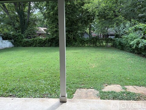 A grassy area with a pole in the foreground.