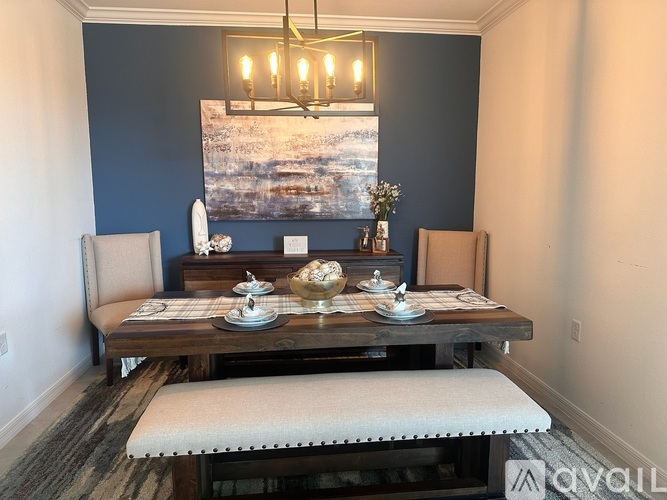 A dining room with a wooden table set for two.