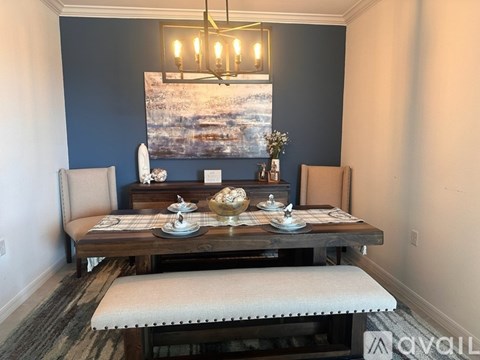 A dining room with a wooden table set for two.