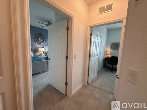A bedroom with a bed and a desk is visible through an open door.