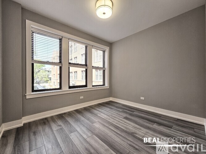 A room with a window and a wooden floor.
