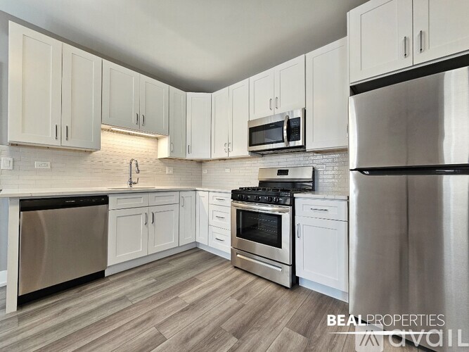 A kitchen with white cabinets and stainless steel appliances.