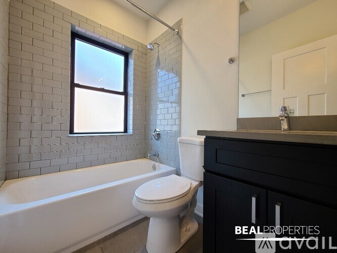 A bathroom with a white tub, toilet, and sink.
