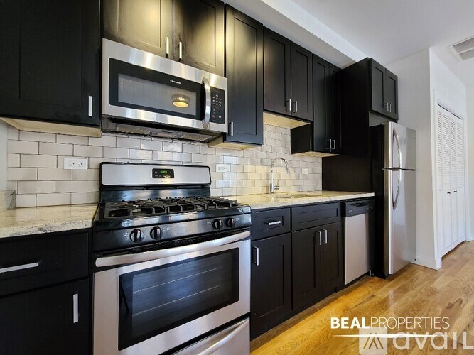 A kitchen with black cabinets and a stove top oven.
