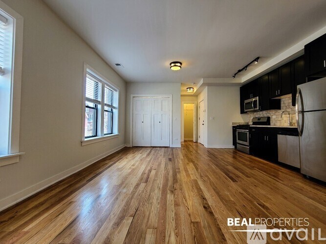 A spacious kitchen with wooden floors and a white ceiling.