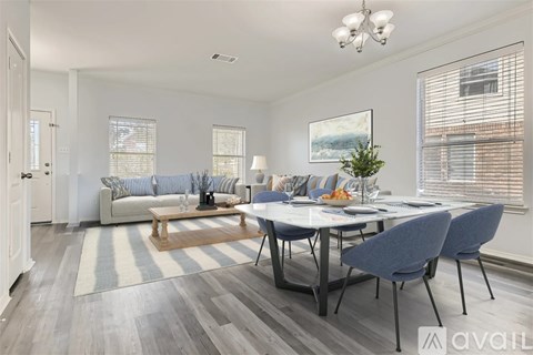 A well-lit living room with a dining table set up with chairs.