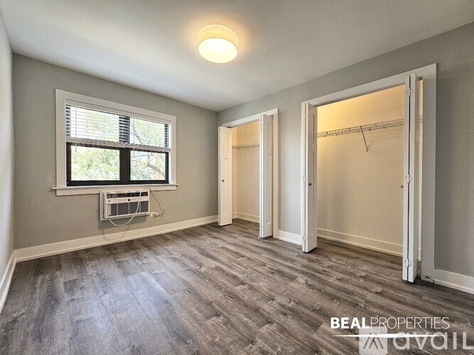 A room with a window and a wall-mounted air conditioning unit.