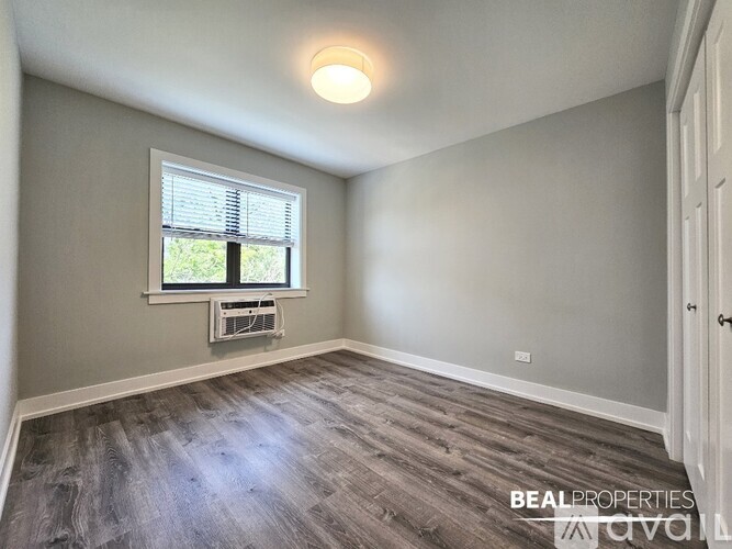A room with a window and a fan on the window sill.