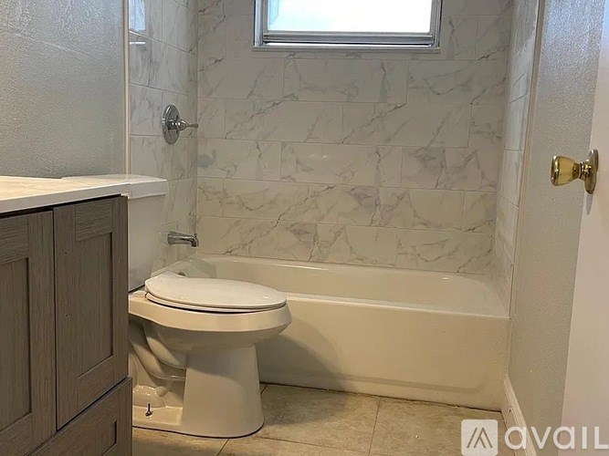 A white toilet in a bathroom with marble tiles.