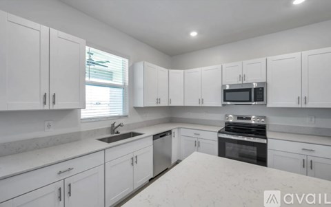 A kitchen with white cabinets and appliances.