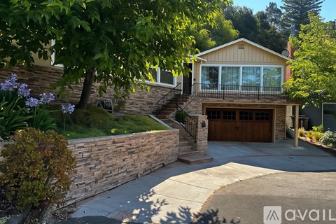 A house with a stone wall and a garage door.