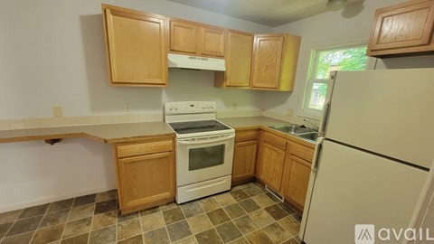 A kitchen with wooden cabinets and a white refrigerator.