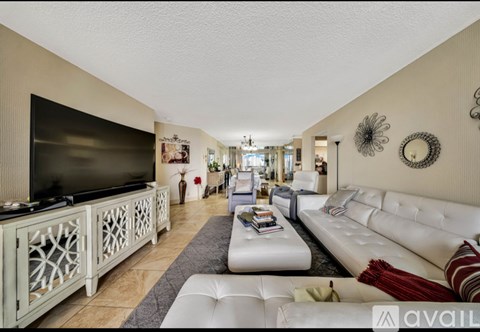 A living room with a white couch and a television.
