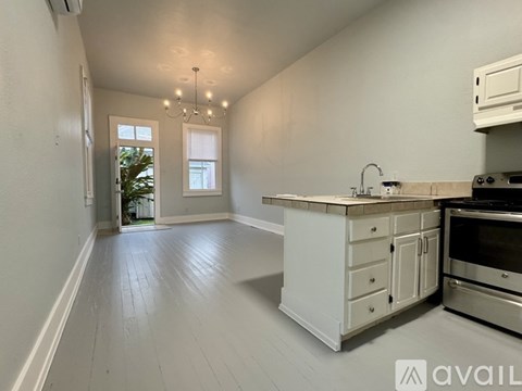 A kitchen with white cabinets and a wooden countertop.