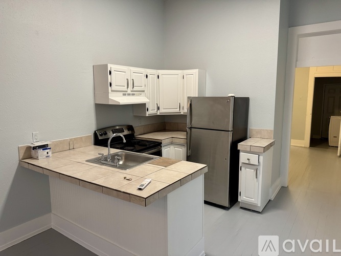 A kitchen with a sink, stove, and refrigerator.