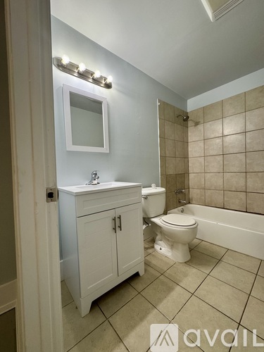 A bathroom with a toilet, sink, and a mirror.