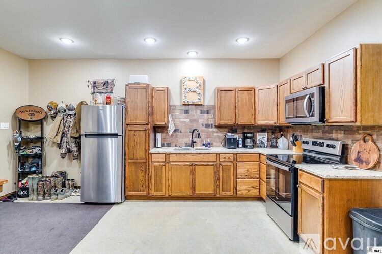 A kitchen with wooden cabinets and a stainless steel refrigerator.