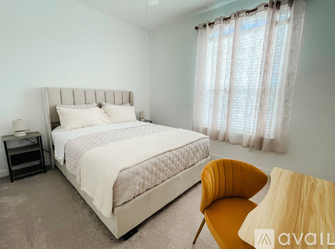 A bedroom with a large bed and a yellow chair.