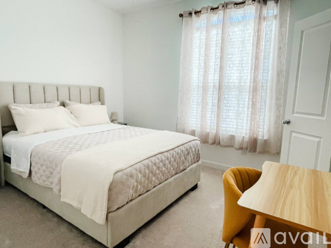 A bedroom with a large bed, a chair, and a nightstand.