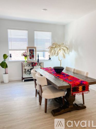 A dining room with a wooden table and chairs.