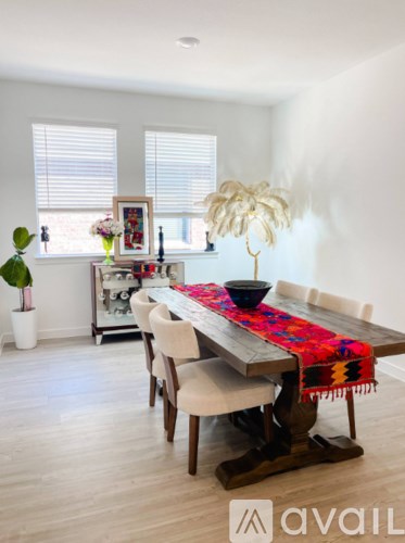 A dining room with a wooden table and chairs.