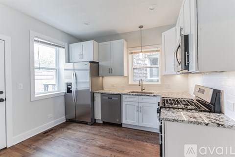 A kitchen with white cabinets and a granite countertop.