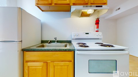 A kitchen with a white fridge, a white stove, and a yellow cabinet.