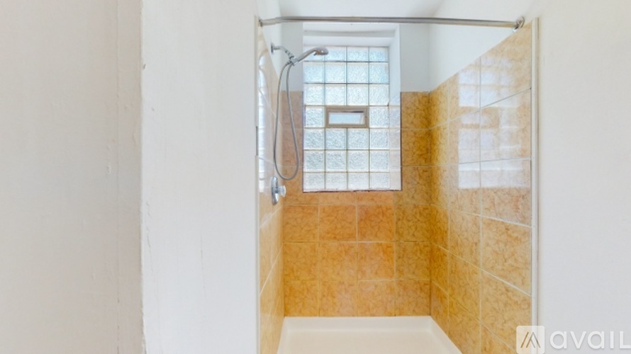 A room with wooden floors and white walls, featuring a white door with glass panels and a white cabinet with glass panels.