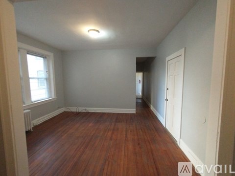 A room with wooden floors and two open doors.