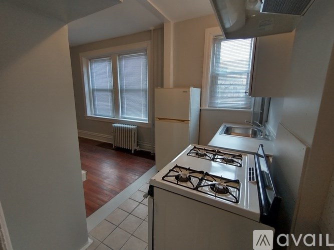 A kitchen with a stove, sink, and refrigerator.