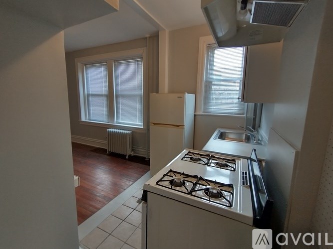 A kitchen with a stove, sink, and window.