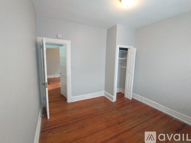 A room with wooden floors and two open doors.