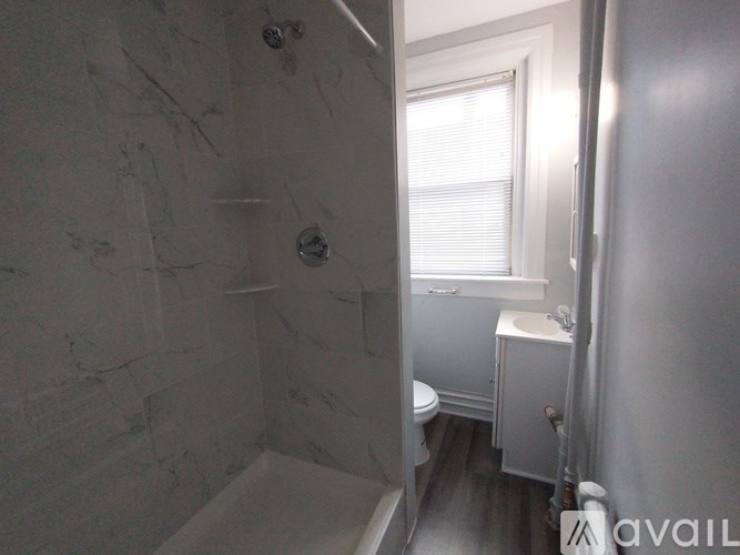 A bathroom with a marble wall and a toilet.