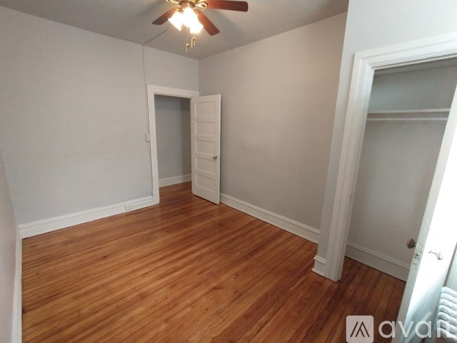 A room with a white door and wooden floors.