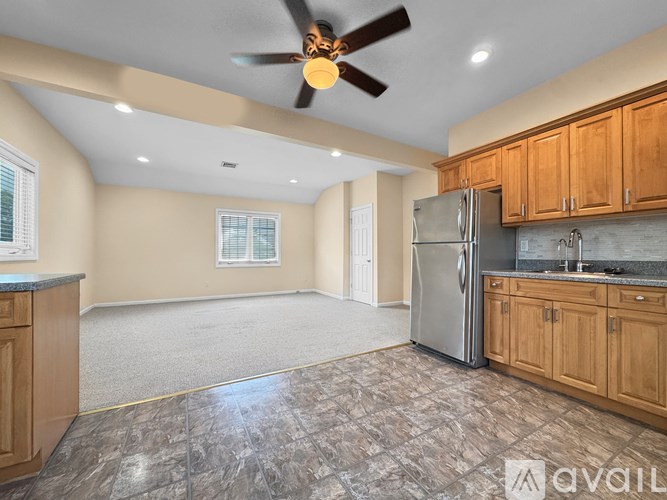A kitchen with wooden cabinets and a ceiling fan.