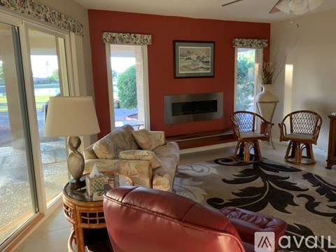A living room with a red couch and a fireplace.