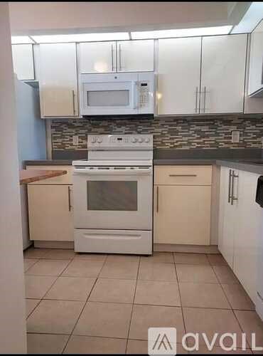 A kitchen with a white oven and microwave.