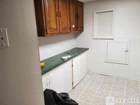 A kitchen with wooden cabinets and a green countertop.