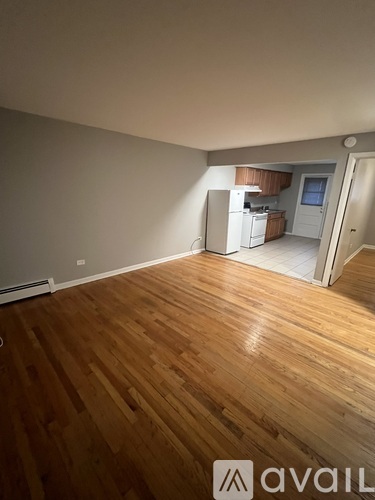 A room with wooden flooring and a window.