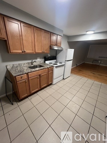 A kitchen with wooden cabinets and a white fridge.
