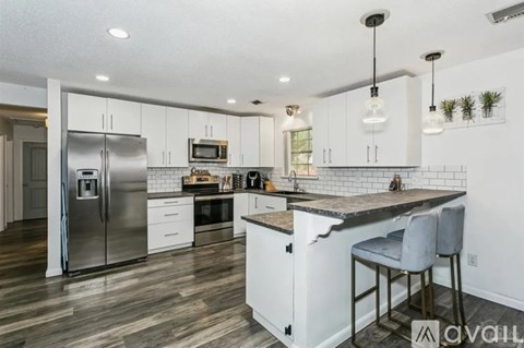 A modern kitchen with a refrigerator, oven, and sink.