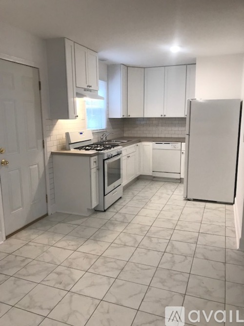 A kitchen with white appliances and cabinets.