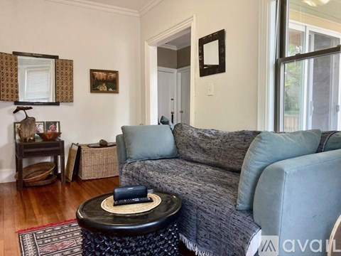 A living room with a grey couch and a black coffee table.