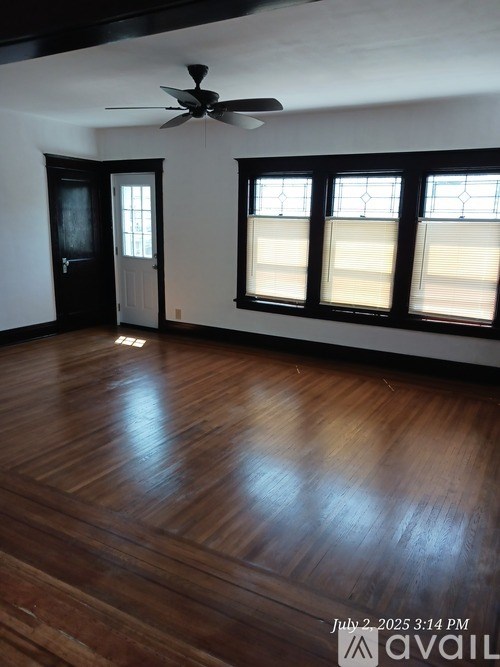 A room with wooden floors and a ceiling fan.